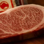 Side-by-side photo of raw Japanese Wagyu beef cuts from Japanese Black, Japanese Brown, and Japanese Shorthorn cattle, showing differences in marbling and texture.