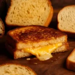 Grilled cheese sandwich oozing melted cheese surrounded by assorted artisan bread slices on a wooden board, with a softly blurred kitchen background.