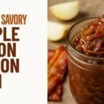 A glass jar filled with maple onion bacon jam, topped with caramelized bits of bacon and onions, with a spoon on a rustic wooden surface.